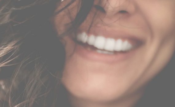 Photo d'une femme qui sourit pour illustrer cet article sur les produits essentiels pour l'hygiène des dents