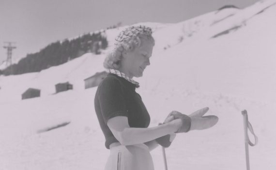 Photo vintage d'une femme à la montagne pour illustrer cet article sur les choses indispensables à ne surtout pas oublier d'emporter en voyage à la montagne en hiver quand il neige